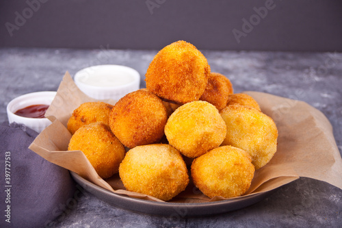 Potato croquettes balls on the plate and dips sauces
