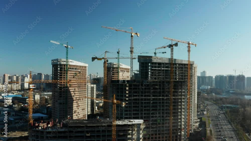 Fly over the construction site, work as construction personnel, builders work, construction houses. Aerial Flight Over a New Constructions Development Site with High Tower Cranes Building Real Estate. Fly over the construction site, work as construction personnel, builders work, construction houses. Aerial Flight Over a New Constructions Development Site with High Tower Cranes Building Real Estate.