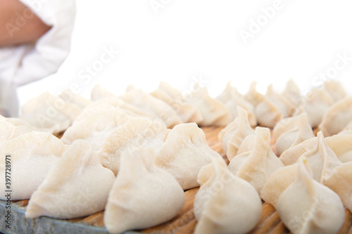 White flour dumplings wrapped on a tray in front of white background