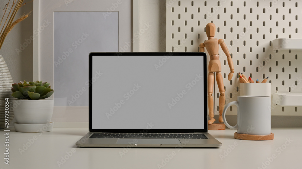 Worktable with laptop, supplies and decorations in home office room Worktable with laptop, supplies and decorations in home office room