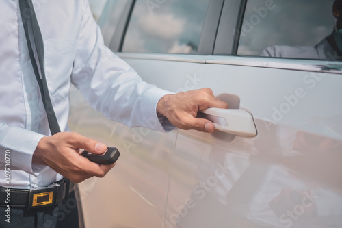 Businessman holding key car opening car door