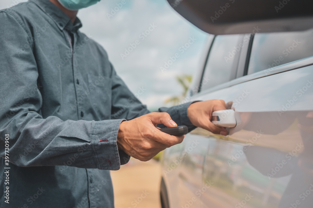 Businessman wear face mask holding key opening car door Businessman wear face mask holding key opening car door