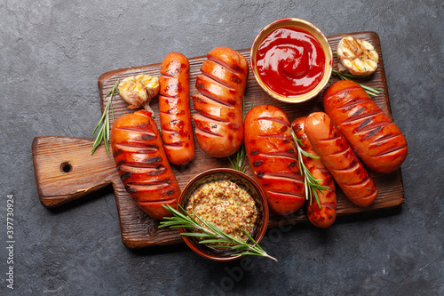 Hot grilled sausages on cutting board