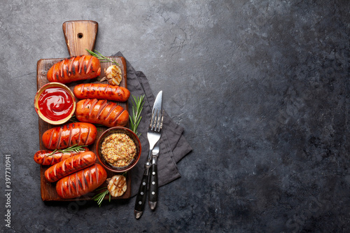 Hot grilled sausages on cutting board