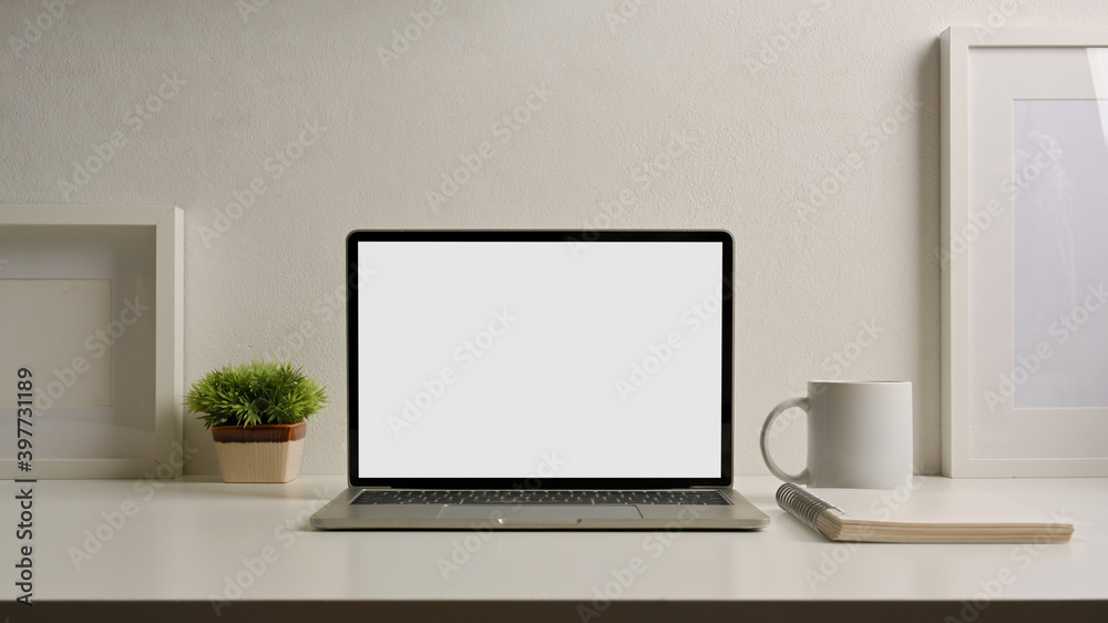Close up view of home office desk with laptop, stationery and decorations Close up view of home office desk with laptop, stationery and decorations