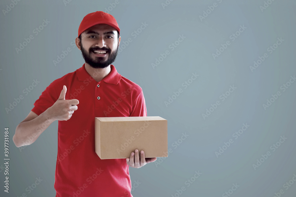 Smiling delivery man holding cardboard box