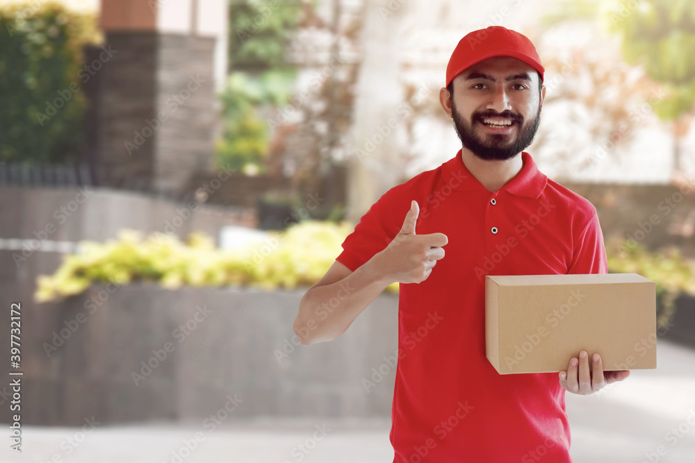 Smiling delivery man holding cardboard box Smiling delivery man holding cardboard box