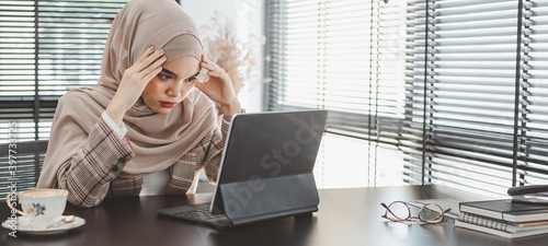 Tired frustrated young muslim business woman brown hijab feeling stressed holding head with hands, business problem failure concept photo