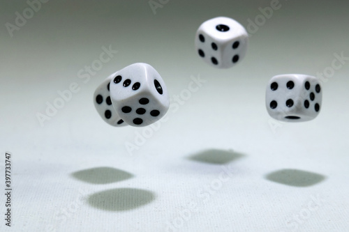  White playing dice cubes in motion on the white canvass surface