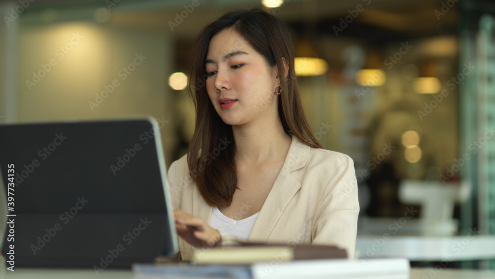 Businesswoman working with tablet in modern office room