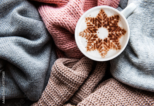 Coffee with a snowflake pattern on a warm knitted sweaters
