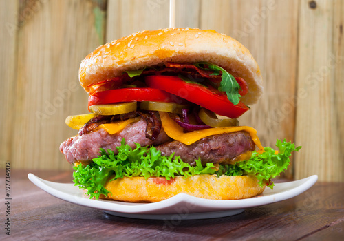Appetizing double cheeseburger with two grilled beef patties and bacon.