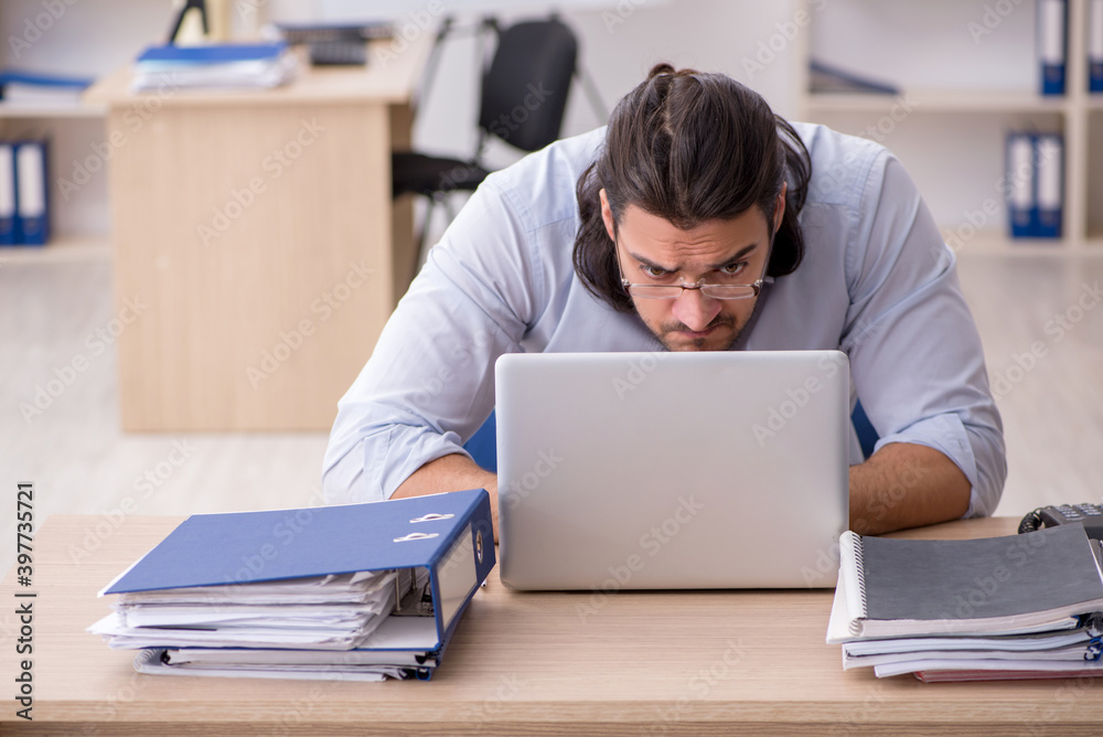Young male employee unhappy with excessive work Young male employee unhappy with excessive work