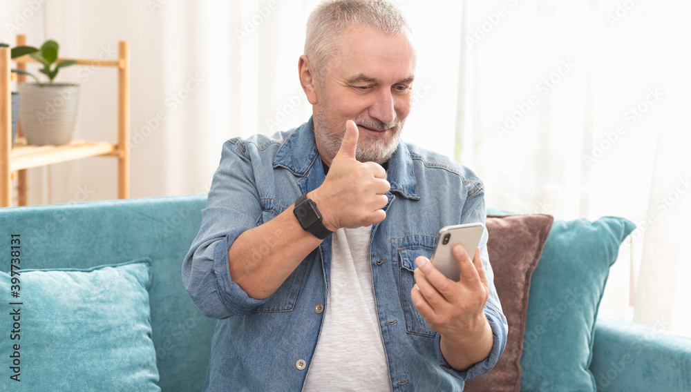 Elderly modern man communicating online chat, showing thumbs up Elderly modern man communicating online chat, showing thumbs up