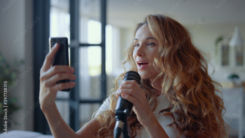 Woman with smartphone singing karaoke. Female vocalist learning text of new song Woman with smartphone singing karaoke. Female vocalist learning text of new song