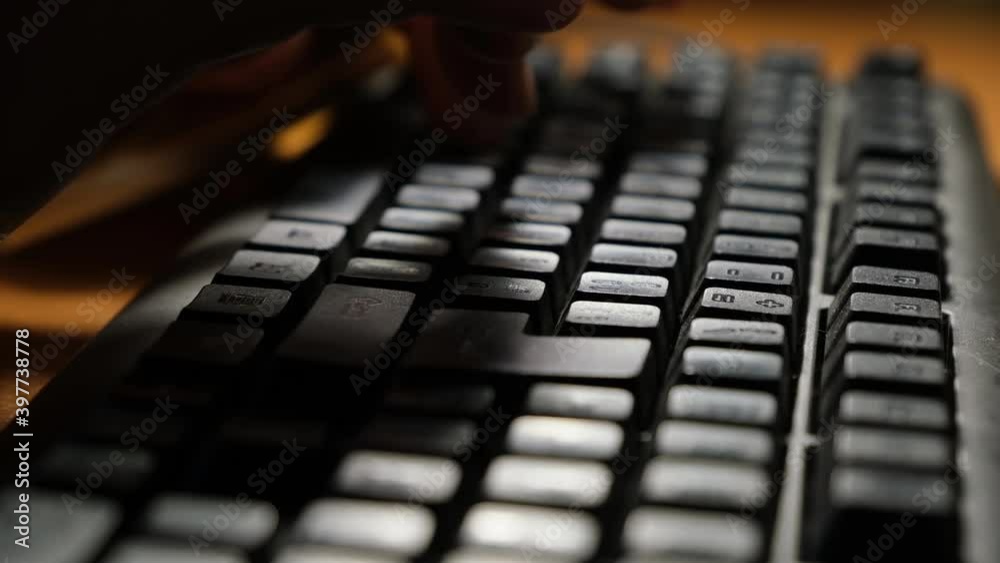 Male hands typing words on keyboard with backlight