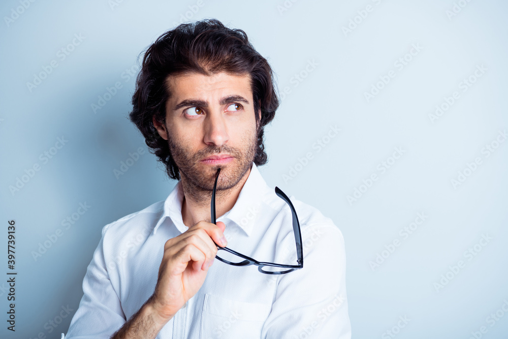 Photo portrait of minded guy looking at blank space touching face chin with glasses taken off isolated on clear white colored background Photo portrait of minded guy looking at blank space touching face chin with glasses taken off isolated on clear white colored background