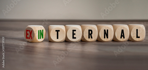 Cubes, dice or blocks showing the words external and internal on wooden background