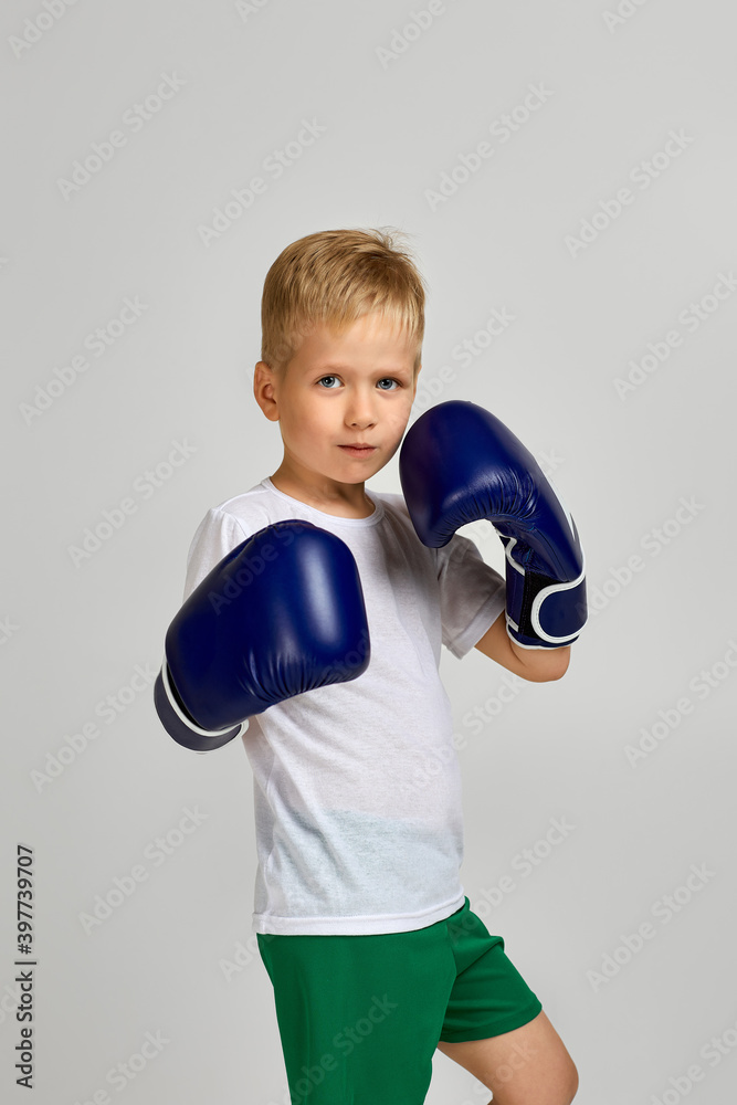 little boxing fighter boy in blue boxer gloves. child dreams of becoming a boxing champion little boxing fighter boy in blue boxer gloves. child dreams of becoming a boxing champion