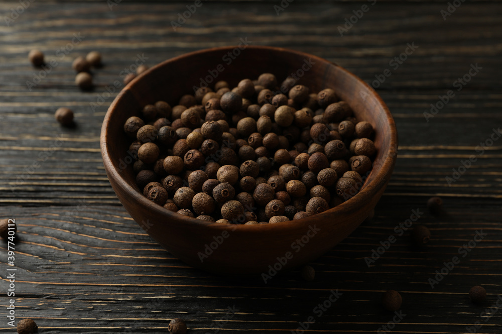 Bowl with peppercorns on wooden table, close up Bowl with peppercorns on wooden table, close up