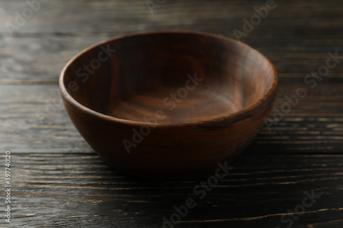 Empty wooden bowl on wooden table, close up