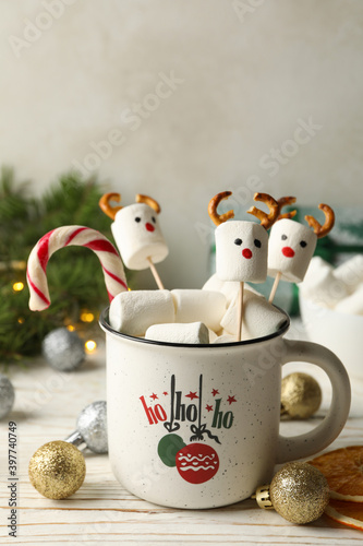 Cup with marshmallow on Christmas wooden background