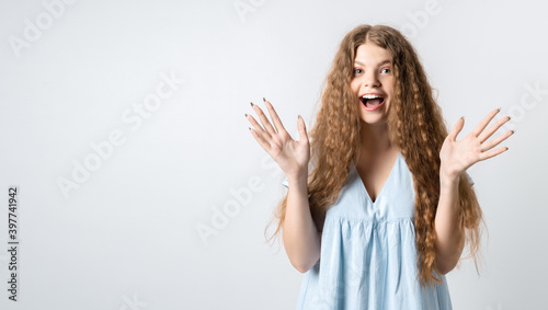 Surprised girl is opening eyes widely and gesturing emotionally, feels glad