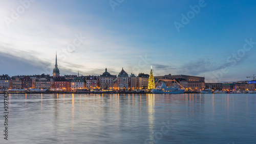 Stockholm city skyline of Gamla Stan (old city) at dusk with Christmas tree beside the harbor