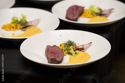 medium grilled cut pork steak with blood on the plate with parsnip puree and corn