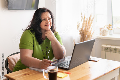 Cute woman in the office sitting at a Desk with a laptop