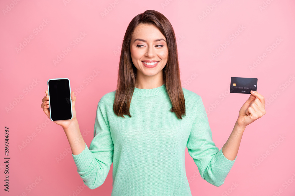 Photo of lady hold telephone look screen empty space credit card toothy smile wear turquoise sweater isolated pink color background Photo of lady hold telephone look screen empty space credit card toothy smile wear turquoise sweater isolated pink color background