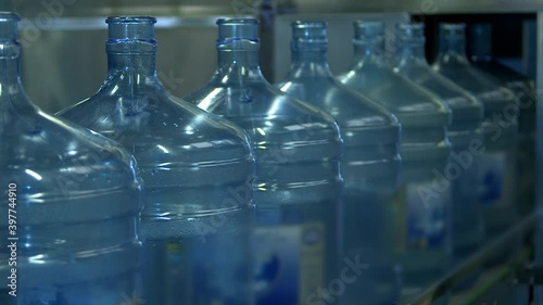 Cooler water bottles in row on factory conveyor