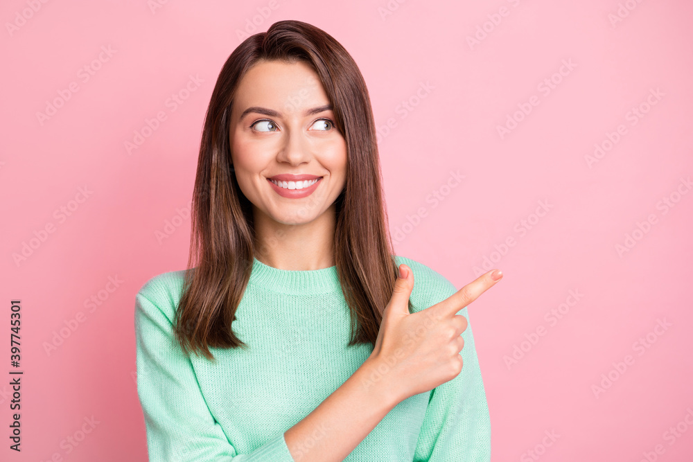 Photo of lovely girl direct forefinger look empty space toothy smile wear teal pullover isolated pink color background Photo of lovely girl direct forefinger look empty space toothy smile wear teal pullover isolated pink color background
