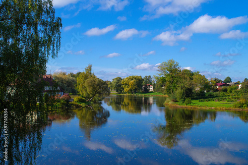Nice view of the lake and small houses on the shore. Lake Jaunpils on a clear sunny day.