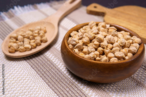 Chickpeas in a wooden bowl on kitchen table. Raw chickpeas close-up