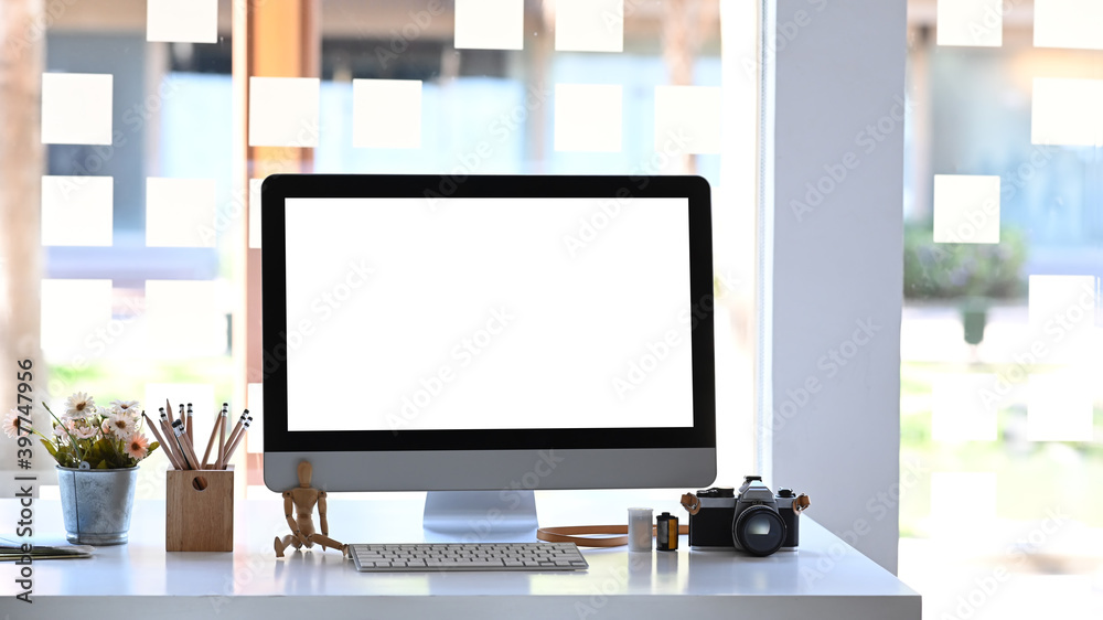 Fototapeta premium Front view of modern workspace with computer, camera and plant on wooden table.