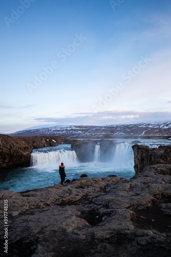 A woman looking at Godafoss Waterfall in Iceland
