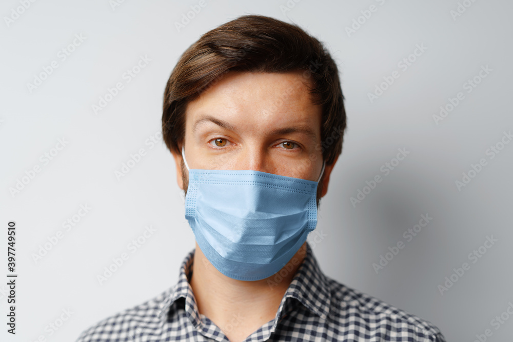 Man wearing hygienic mask against grey background Man wearing hygienic mask against grey background