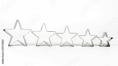 Fototapeta Naklejka Na Ścianę i Meble -  Metal forms for cookies in the shape of a star on a white background in a row.