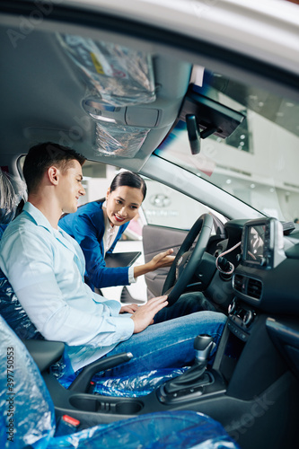 Dealership manager giving smiling customer some instructions on test driving photo