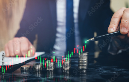 Businessman holding coin stack with digital increase graph. Business growing financial concept.