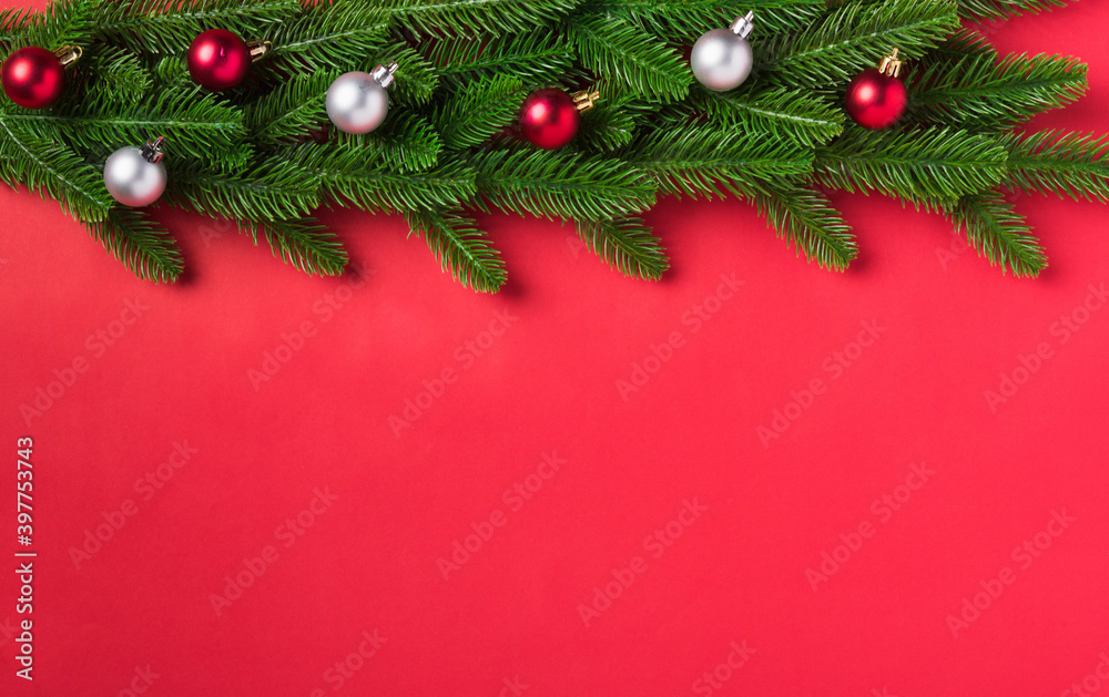 Christmas background presents greeting card with top view overhead green fir tree branches and decoration, Xmas holiday celebration season on red table background with copy space