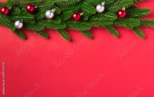 Christmas background presents greeting card with top view overhead green fir tree branches and decoration, Xmas holiday celebration season on red table background with copy space