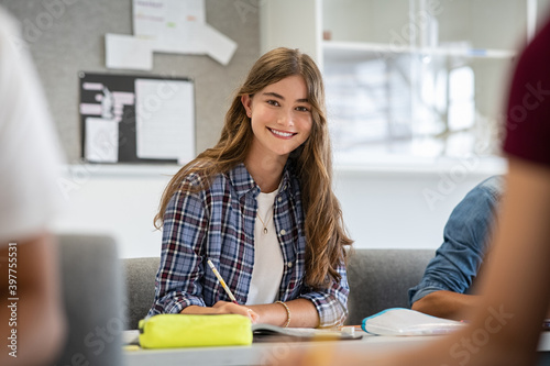Smiling college girl studying in classroom photo