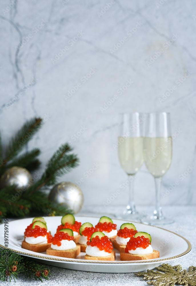 Toasts with cheese and red caviar on a New Year's table with champagne. New Year's table. Snack.