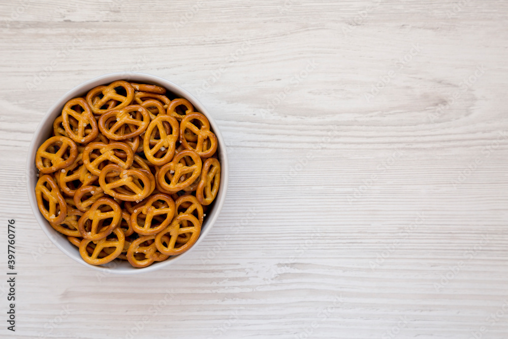 Crispy Pretzel Crackers in a Gray Bowl on a white wooden background, top view. Flat lay, overhead, from above. Space for text. Crispy Pretzel Crackers in a Gray Bowl on a white wooden background, top view. Flat lay, overhead, from above. Space for text.
