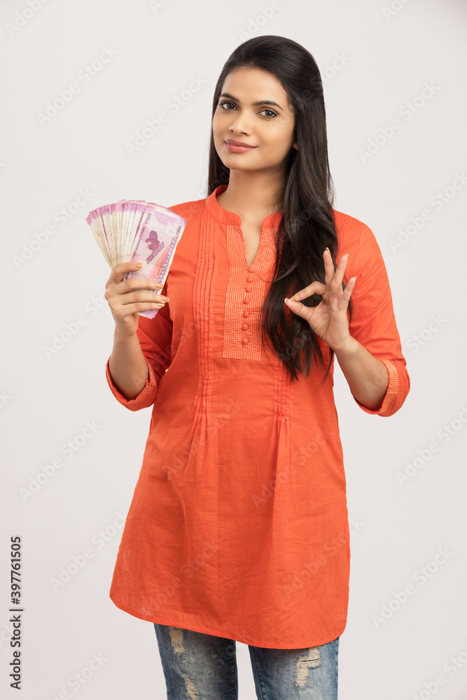 Happy young woman holding Indian 2000 rupee notes on white. Happy young woman holding Indian 2000 rupee notes on white.