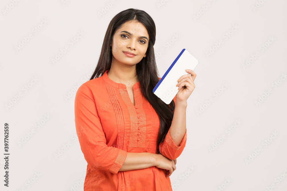 Young beautiful tourist woman holding boarding pass ticket on white Young beautiful tourist woman holding boarding pass ticket on white