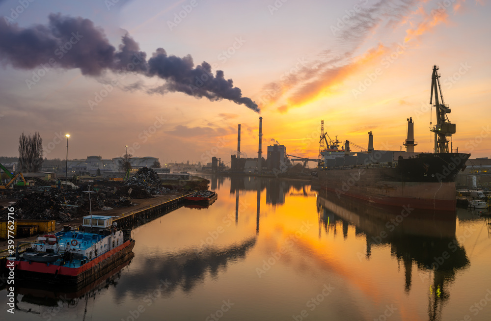 panorama of the industrial landscape - a smoking power plant, a bulk cargo ship in a shipyard, a scrap recycling station