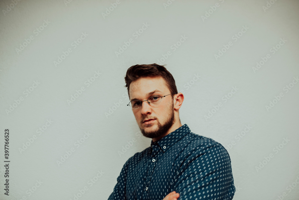 a portrait of a successful caucasian businessman wearing glasses and a blue shirt